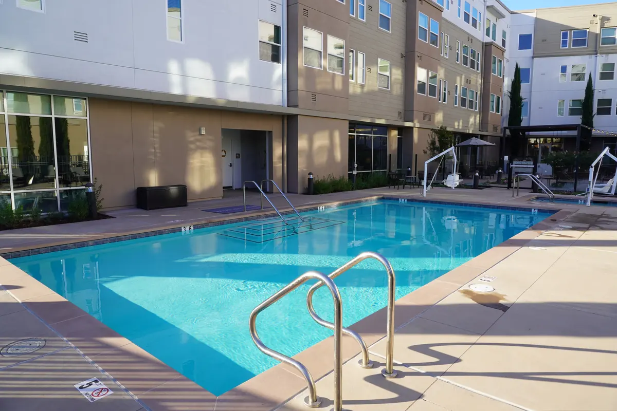 A clean courtyard pool with a chrome ladder.