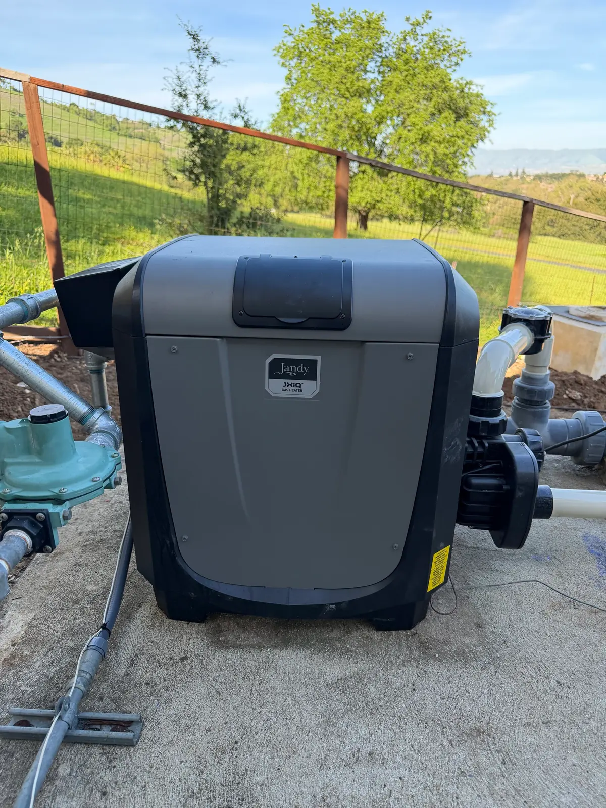 A gas pool heater installed beside the pump and plumbing.