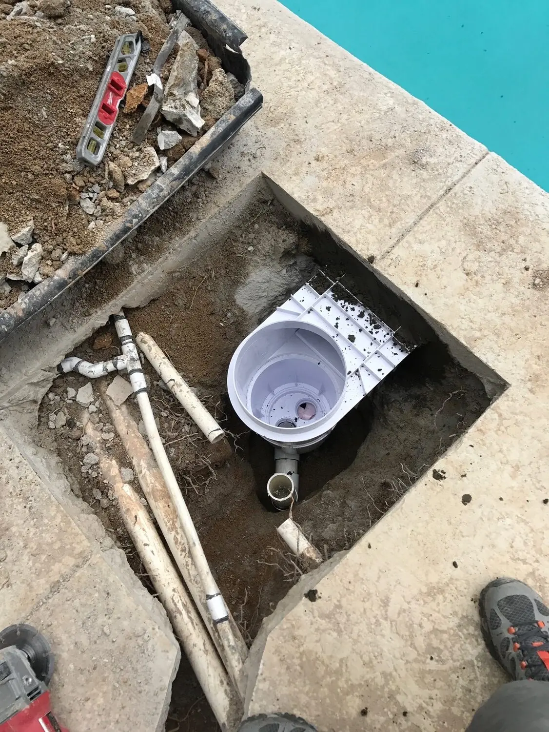 A section of pool deck opened up to reach the plumbing.